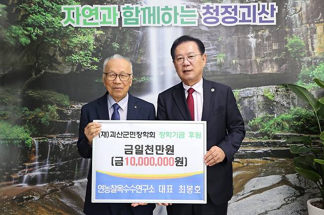 최봉호(왼쪽) 전 충남대 교수가 지난해 4월 충북 괴산군을 찾아 송인헌 괴산군수에게 장학금 1천만원을 건넸다. 괴산군 제공