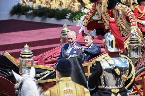 8일 영국 런던 서쪽 윈저성 인근에서 열린 환영식에서 마차 행진을 하고 있는 찰스 3세 영국 국왕(왼쪽)과 에마뉘엘 마크롱 프랑스 대통령. 로이터=연합뉴스