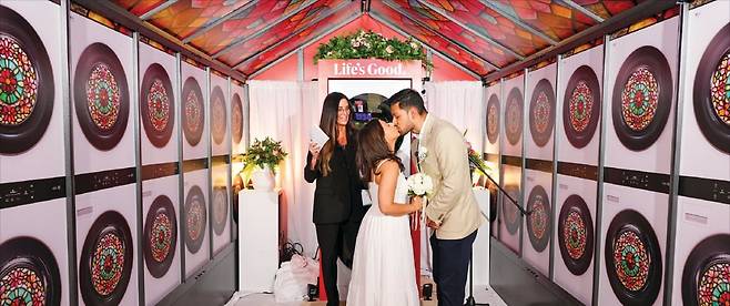 LG전자가 최근 뉴욕에서 진행한 결혼 서약식 ‘러브 투 런드리’에서 참가자들이 복합형 세탁건조기 워시타워 앞에서 기념 촬영을 하고 있다.  LG전자 제공