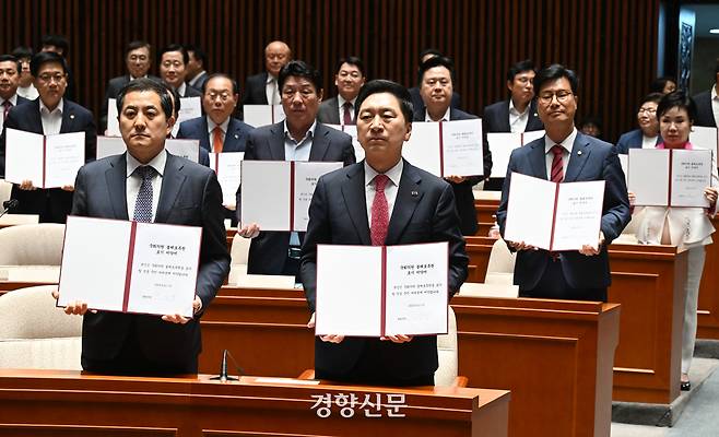 2023년 6월21일 김기현 당시 국민의힘 대표와 소속 의원들이 국회에서 열린 의원총회에서 ‘국회의원 불체포특권 포기 서약서’를 들어보이고 있다. 박민규 선임기자