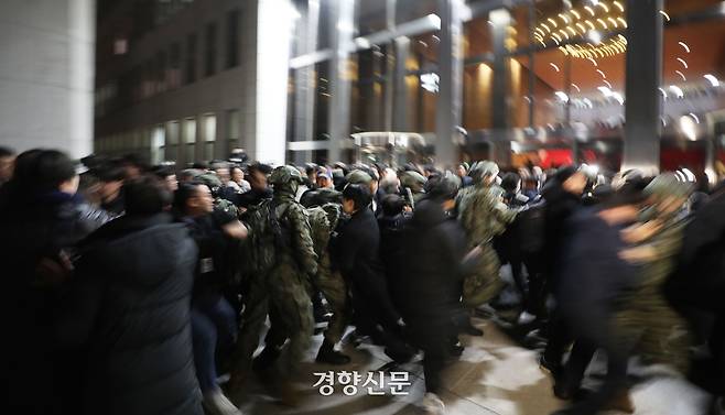 윤석열 전 대통령의 비상계엄을 선포한 다음 날인 지난해 12월 4일 계엄군이 서울 여의도 국회 본관으로 진입을 시도하자 시민들이 서로 손을 잡고 저지하고 있다. 한수빈 기자