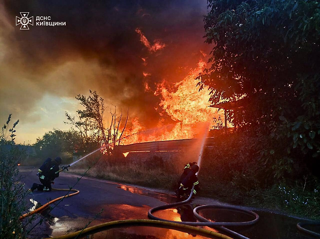 우크라이나 응급대원이 9일(현지시간) 수도 키이우에서 러시아 공습으로 발생한 화재를 진압하고 있다. AFP연합뉴스