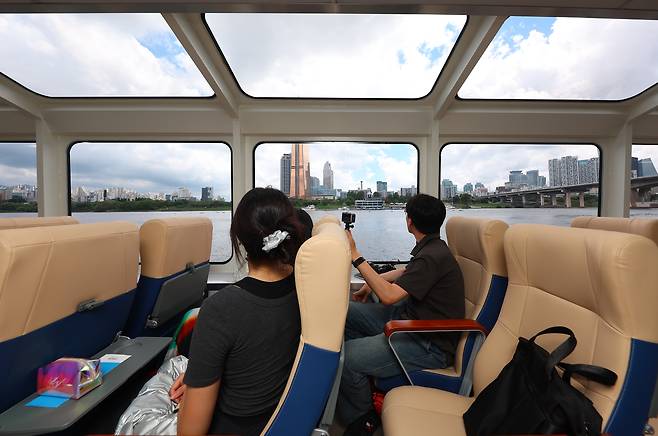 People look at the view from the Hangang Bus during the inaugural trial ride on July 1. [YONHAP]