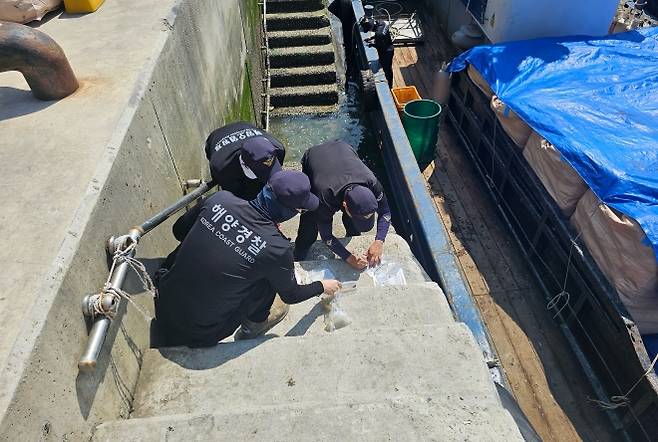 목포해양경찰이 선박에서 방류된 선저폐수 시료를 채취하고 있다. (목포해경 제공)