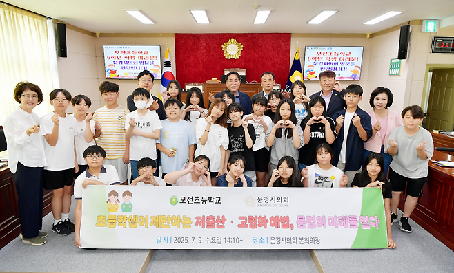 모전초등학교 학생들이 저출산 고령화 해법 현수막을 펼치고 있는 모습. /문경시의회 제공