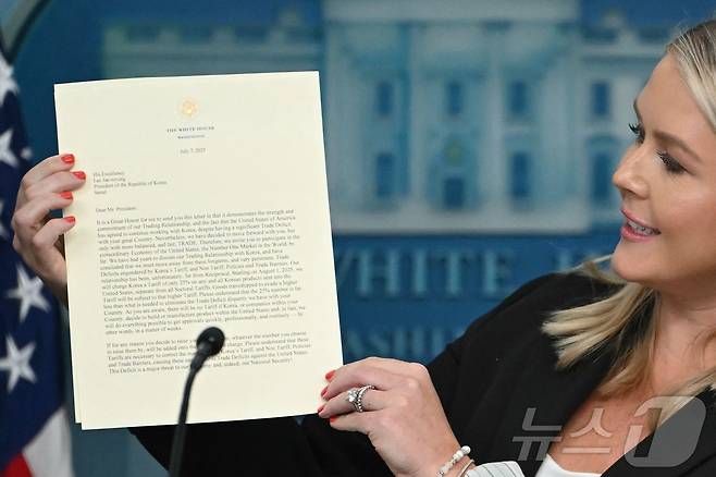캐롤라인 레빗 백악관 대변인이 7일(현지시간) 미국 워싱턴 D.C. 백악관에서 열린 기자 회견에서 도널드 트럼프 미국 대통령이 이재명 대통령에게 보낸 관세 관련 서명 서한을 공개하고 있다. 트럼프 대통령은 이재명 대통령에게 보내는 서한에서 "불행히도 우리 관계는 상호적이지 않았다＂면서 ＂2025년 8월 1일부터, 우리는 한국에서 미국으로 수출되는 모든 제품에 대해 품목별 관세와 별도로 25%의 관세를 부과할 것＂ 이라고 밝혔다. 2025.7.8 ⓒ AFP=뉴스1