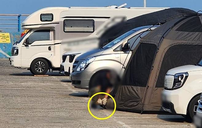 거제 흥남해수욕장 방파제 공영주차장에서 텐트를 설치하기 위해 콘크리트 바닥에 드릴을 뚫는 캠핑족의 모습. /보배드림