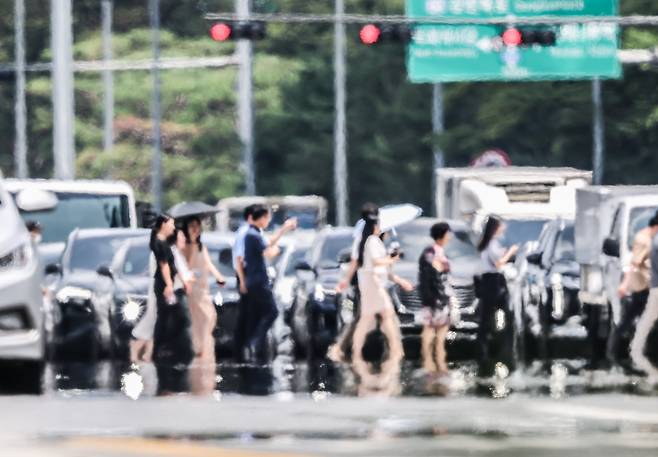 최고기온 오후 36도를 기록한 9일 오후 서울 영등포구 여의대로. 아스팔트에서 아지랑이가 피어오르는 가운데 시민들이 발걸음을 옮기고 있다. /고운호 기자