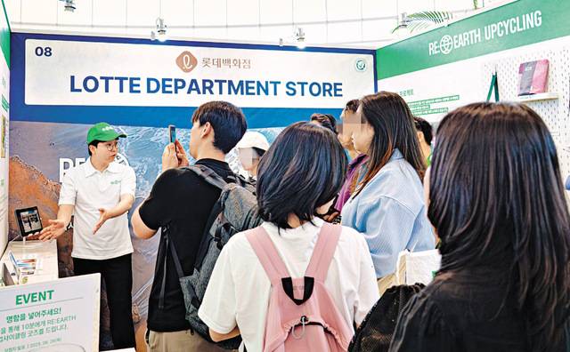 롯데백화점이 중고 패션 상품을 엘포인트로 교환해주는 ‘그린 리워드 서비스’를 도입한다. 세계 환경의 날을 맞아 지난달 제주 국제컨벤션센터에서 운영한 ESG(환경·사회·지배구조) 캠페인 ‘리얼스(RE:EARTH)’ 홍보 부스에서 방문객들이 백화점 폐기물을 활용한 ‘업사이클링 굿즈’를 살펴보고 있다. 롯데백화점 제공