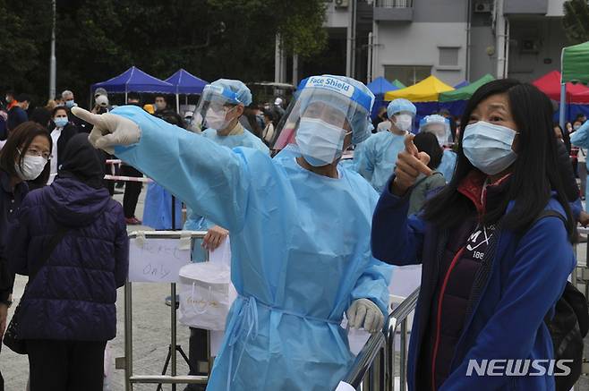 [홍콩=AP/뉴시스]  2022년 2월 10일 홍콩 란타우섬 디스커버리 베이에 마련된 코로나19 임시 검사소에서 검사를 받으려는 한 주민이 안내를 받고 있다. 2025.07.10.