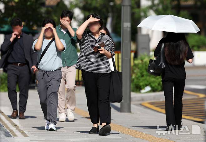 [서울=뉴시스] 조성우 기자 = 폭염이 계속되는 10일 서울 종로구 거리에서 시민이 손으로 햇볕을 피하며 이동하고 있다. 2025.07.10. xconfind@newsis.com