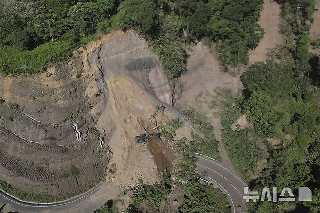 [팔린=AP/뉴시스] 과테말라에서 규모 5.7의 지진이 발생한 가운데 9일(현지 시간) 팔린에서 굴착기가 산사태로 막힌 도로를 정리하고 있다. 현지 당국은 지난 8일 오후부터 규모 3.0에서 5.7의 본진과 여진이 150차례 이상 이어지며 최소 4명이 숨졌다고 밝혔다. 2025.07.10.