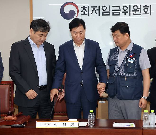 지난 10일 정부세종청사에서 열린 제12차 전원회의에서 내년 최저임금을 시간당 1만320원으로 17년만에 합의로 결정한 뒤 이인재 위원장(왼쪽부터), 사용자위원인 류기정 한국경영자총협회 전무, 근로자위원인 류기섭 한국노총 사무총장이 기념촬영을 위해 손을 잡고 있다. (사진=연합뉴스)