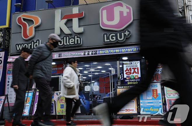 서울의 한 휴대폰 매장 앞으로 시민이 지나가고 있다. 2025.3.12/뉴스1 ⓒ News1 박정호 기자