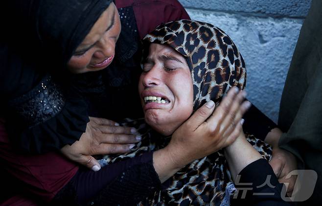 가자지구 남부 칸유니스에 있는 나세르병원에서 이스라엘의 공격으로 사망한 팔레스타인인들의 장례식에서 사람들이 울고 있다. 2025.7.9 ⓒ 로이터=뉴스1 ⓒ News1 김경민 기자