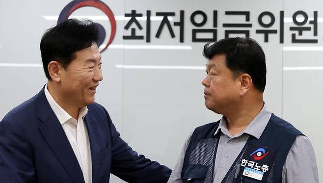 10일 밤 세종시 정부세종청사에서 열린 최저임금위원회 전원회의에서 2026년도 적용 최저임금이 1만 320원으로 결정됐다.    회의가 끝난 후 류기정 사용자 위원과 류기섭 근로자 위원이 악수하고 있다. 이날 민주노총은 공익위원이 제시한 심의촉진구간에 반발, 집단 퇴장했다. 2025.07.10.뉴시스