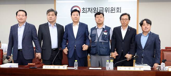 최저임금위원회 이인재 위원장과 권순원 공익위원, 류기정 사용자 위원, 류기섭 근로자 위원 등이 지난 10일 밤 세종시 정부세종청사에서 2026년도 적용 최저임금안을 합의로 결정한 뒤 손을 맞잡고 있다.   내년도 최저임금은 1만 320원으로 결정됐다. 2024.07.11. /사진=뉴시스