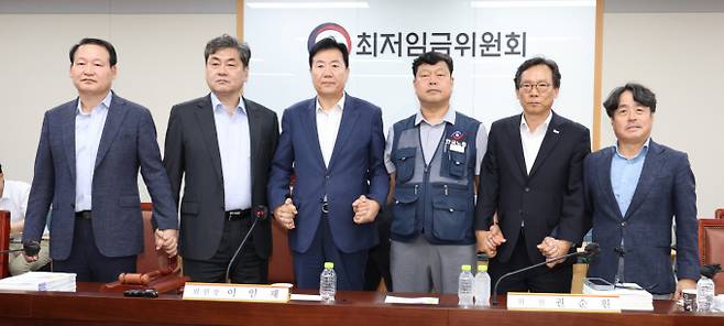 최저임금위원회 이인재 위원장과 권순원 공익위원, 류기정 사용자 위원, 류기섭 근로자 위원 등이 지난 10일 밤 세종시 정부세종청사에서 2026년도 적용 최저임금안을 합의로 결정한 뒤 손을 맞잡고 있다. / 사진=뉴시스 강종민 기자 /사진=강종민