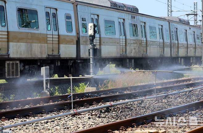 [서울=뉴시스] 전진환 기자 = 전국적인 폭염이 이어지고 있는 11일 서울 강서구 서울시메트로9호선 김포차량기지에서 운행을 마친 전동차가 들어오는 레일 주위로 '자동살수장치'가 가동되고 있다.  자동살수장치는 여름철 레일 온도가 일정 수준 이상으로 상승할 경우 자동으로 물을 분사해 온도를 낮추는 장치다. 2025.07.11. amin2@newsis.com