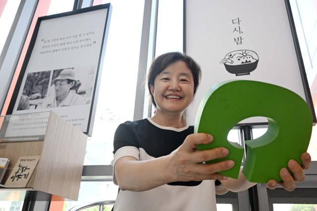 권옥자 한살림 상임대표가 서울 서초구 사무소에서 진행된 인터뷰를 마친 후 생명을 상징하는 떡잎을 중심으로 양팔로 대지를 감싸안는 모양의 한살림 CI 모형을 들고 포즈를 취하고 있다. 조태형 기자