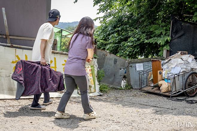 권학근씨(왼쪽)와 남혜영씨가 고양이들의 밥 자리로 향하자, 흰 고양이가 마중을 나왔다. ⓒ시사IN 박미소