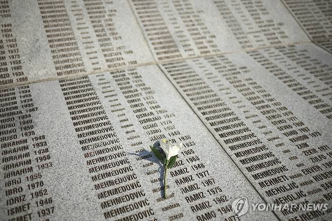 스레브레니차 학살 희생자들의 이름이 새겨진 추모비 위에 놓인 꽃 한송이 [AP 연합뉴스. 재판매 및 DB 금지]