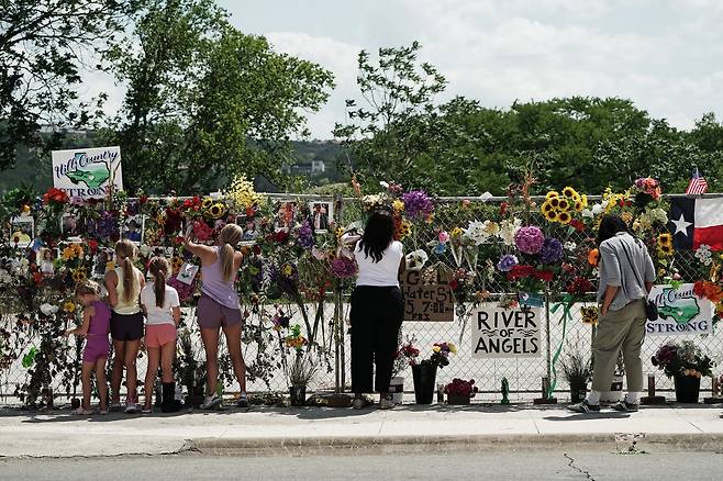 텍사스주 주민들이 11일 홍수 사태가 발생한 피해 지역 인근에서 희생자들을 추모하고 있다. /EPA 연합뉴스