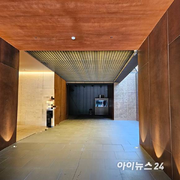 더파크사이드 스위트 견본주택 입구로, 한 직원이 고객을 기다리고 있다. 이 견본주택은 입구에 도착하면 직원이 내방객의 차 문을 열어준다. 차량은 발렛 파킹 해준다. [사진=이효정 기자 ]