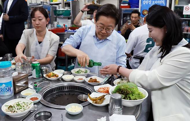 이재명 대통령이 11일 저녁 서울 광화문 인근 한식당에서 시민들과 식사 중 술을 따르고 있다. 연합뉴스