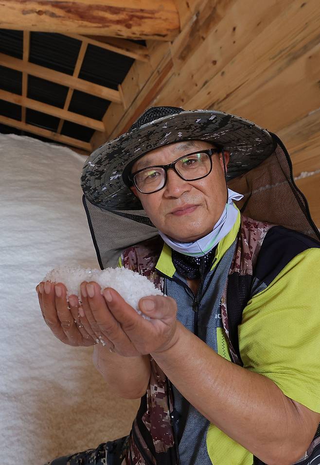 염부 전동길 씨가 소금창고에서 수확한 소금을 들어보이고 있다.