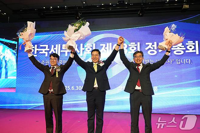 구재이 회장(가운데)이 지난달 30일 서울 코엑스에서 열린 ‘제63회 한국세무사회 정기총회’에서 김완일 후보를 제치고 연임에 성공했다.(한국세무사회 제공. 재판매 및 DB금지)/뉴스1