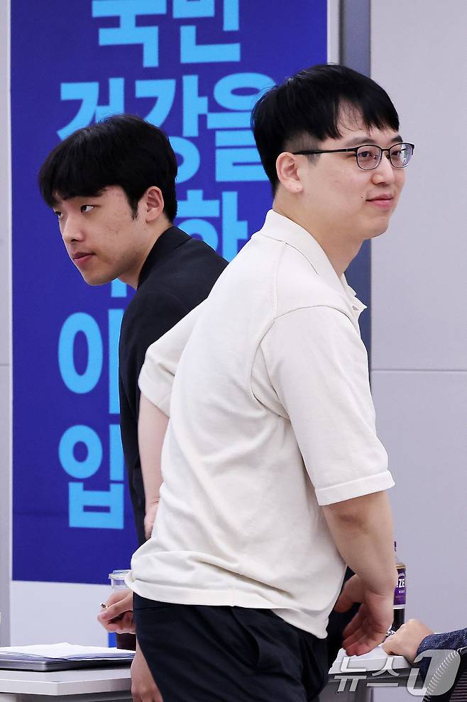 한성존 대한전공의협의회 비상대책위원장(오른쪽)과 이선우 대한의과대학·의학전문대학원학생협회 비대위원장이 13일 서울 용산구 대한의사협회 대강당에서 열린 제1회 전국의사 의료정책 심포지엄에서 인사를 나눈 뒤 자리를 이동하고 있다. 2025.7.13/뉴스1 ⓒ News1 박지혜 기자