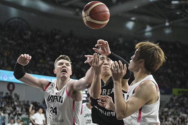 일본의 귀화선수 조시 호킨슨(왼쪽)과 볼다툼을 벌이고 있는 한국 대표팀 문정현(가운데). 대한민국농구협회 제공.
