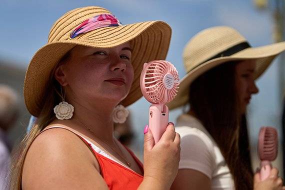 지난 1일(현지시간) 스페인 마드리드에서 시민들이 개인용 소형 선풍기로 더위를 쫓고 있다.