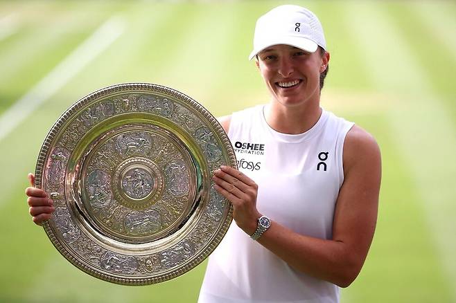 이가 시비옹테크(폴란드)가 12일(현지시각) 영국 런던 올 잉글랜드 클럽에서 열린 윔블던 여자 단식 결승에서 어맨다 아니시모바(미국)를 꺾은 뒤 우승 트로피를 들고 환하게 웃고 있다. 런던/AFP 연합뉴스