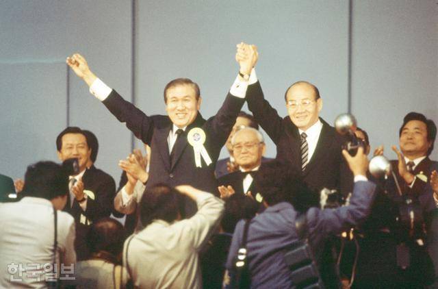 1987년 민주정의당 전당대회에서 차기 대통령 선거 후보로 지명된 노태우(기립해 있는 두 명 중 왼쪽) 민정당 대표가 전두환(오른쪽) 당시 대통령과 손을 맞잡고 대의원들 환호에 답하고 있다. 한국일보 자료사진