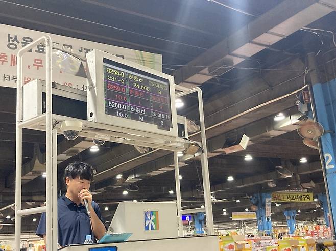 가락시장에서 토마토 경매가 이뤄지고 있다. 모니터에 경매 물품과 가격 등의 정보가 실시간으로 나오고 있다. 모니터 아래 마이크를 든 사람이 경매사다. 손인규 기자