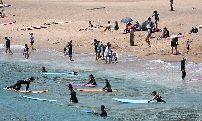 제주 서귀포시 중문색달해수욕장에서 물놀이객이 서핑을 배우며 즐거운 시간을 보내고 있다. 뉴시스