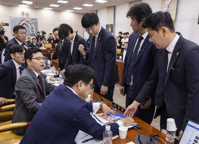 14일 서울 여의도 국회 과학기술정보방송통신위원회에서 열린 배경훈 과학기술정보통신부 장관 후보자 인사청문회에서 국회 경위들이 국민의힘 과방위원들의 피켓을 제거하기 위해 야당 의원석 앞에 서 있다. 연합뉴스 제공.