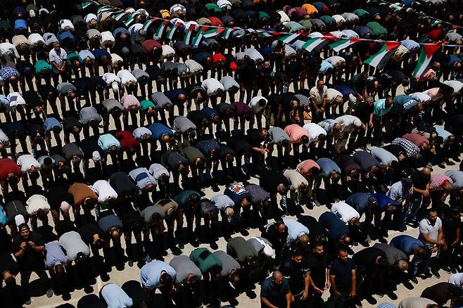 13일(현지시각) 이스라엘이 점령한 서안지구 라말라 인근에서 정착민들에게 구타당해 사망한 팔레스타인계 미국인과 이스라엘군의 총격으로 사망한 팔레스타인인의 장례에 사람들이 참석해 기도하고 있다. 라말라/로이터 연합뉴스