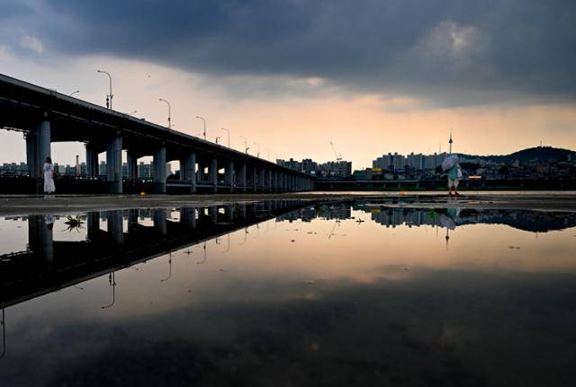 불볕더위와 폭우가 번갈아 왔던 8일 반포 한강공원에 비바람이 물러가자, 먹구름 사이로 붉은 노을이 번지고 있다.