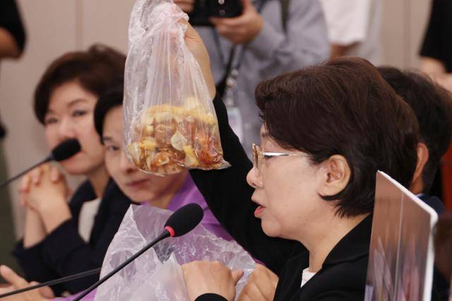 이달희(오른쪽) 국민의힘 의원이 14일 국회 여성가족위원회의 '강선우 여성가족부 장관 후보자 인사청문회'에서 음식물 쓰레기를 들어보이며 강 후보자의 갑질 의혹과 관련한 질문을 하고 있다. 연합뉴스