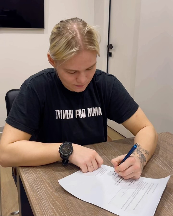 국제종합격투기연맹 세계청소년선수권대회 페더급 금메달리스트 알료나 아기셰바가 2025년 2월18일 대한민국 단체 블랙컴뱃 출전 계약서에 사인하고 있다. 사진@mcgrath