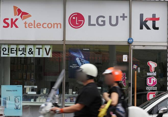SK텔레콤 사이버 침해 사고 위약금 면제 기한이 하루 앞으로 다가온 13일 서울 서대문구의 한 휴대전화 판매점에 이동통신 3사 로고가 붙어 있다. 이번 사고로 촉발된 이통 3사간의 고객유치전이 막바지로 치달으며 보조금 경쟁 등 과열양상을 띄고 있다./사진=뉴시스