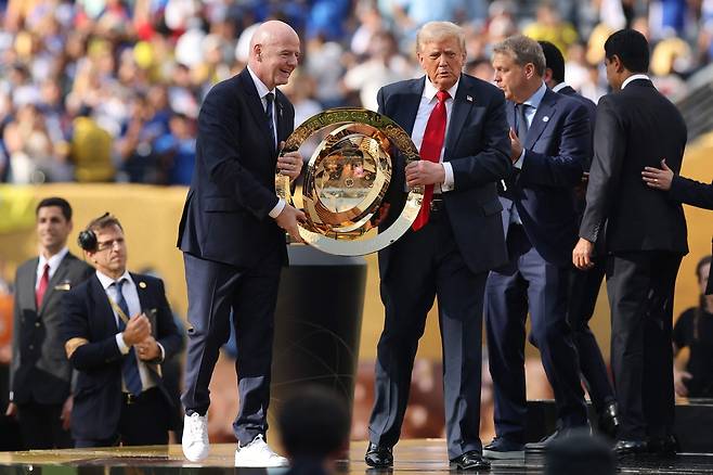 트럼프 대통령이 인판티노 피파 회장과 함께 우승팀에게 줄 트로피를 들어올리고 있다. [AFP]