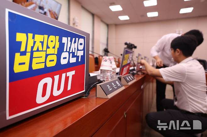 [서울=뉴시스] 고승민 기자 = 14일 서울 여의도 국회에서 열린 강선우 여성가족부 장관 후보자의 인사청문회에 앞서 국민의힘 의원실 관계자들이 소속 의원 노트북에 강 후보자를 규탄하는 피켓을 붙이고 있다. 2025.07.14. kkssmm99@newsis.com