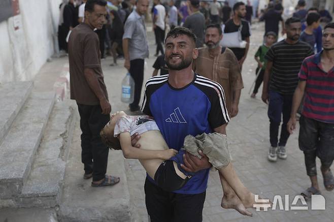 [시파=AP/뉴시스] 12일(현지 시간) 가자지구 시파 병원에서 팔레스타인인이 이스라엘군의 공습으로 사망한 자녀의 시신을 옮기고 있다. 2025.07.14.