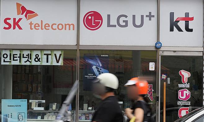 SK텔레콤 해킹 사태 이후 통신 3사가 보조금 상향 등 치열한 가입자 유치전을 벌이고 있는 가운데 13일 서울 서대문구의 한 휴대전화 판매점에 이동통신 3사 로고가 붙어 있다. 뉴시스