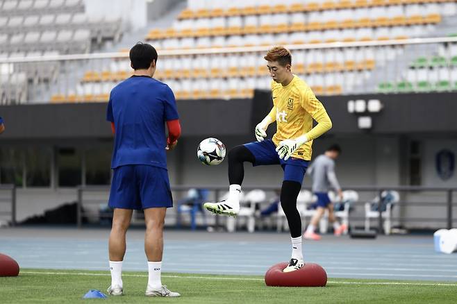 축구국가대표팀 골키퍼이자 주장 조현우(오른쪽)가 성남종합운동장에서 진행된 팀 훈련에서 코치의 도움을 받아 볼을 가볍게 차 올리며 몸을 풀고 있다. 사진제공｜대한축구협회
