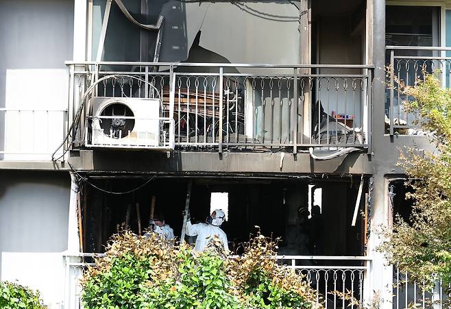 아파트 거실(앞쪽) 감식하는 감시반 (부산=연합뉴스) 손형주 기자 = 14일 부산 북구 만덕동의 한 아파트에서 국과수와 경찰, 소방당국이 합동감식을 벌이고 있다. 거실 발코니는 아파트 화단과 연결돼 있다. 2025.7.14